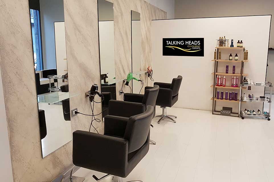 Il Salone parrucchiere a Como, Talkingheads con sedie nere contemporanee e specchi eleganti.
